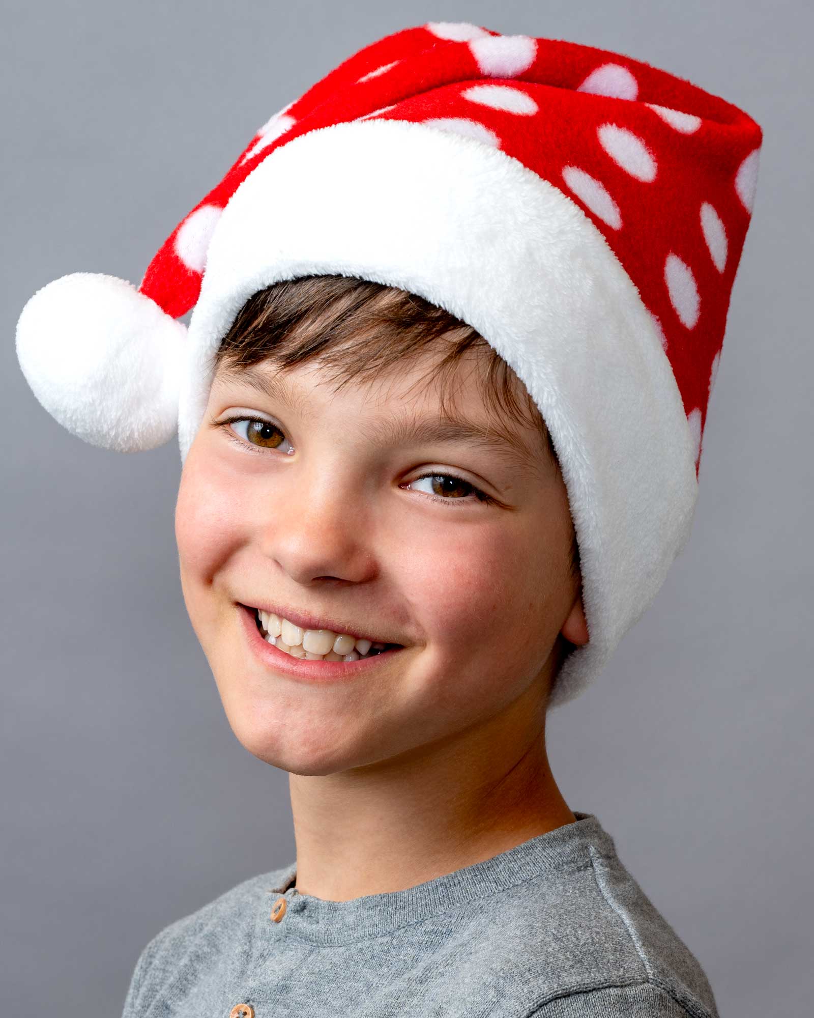 Junge mit handgenähter Weihnachtsmütze mit weißem Bommel