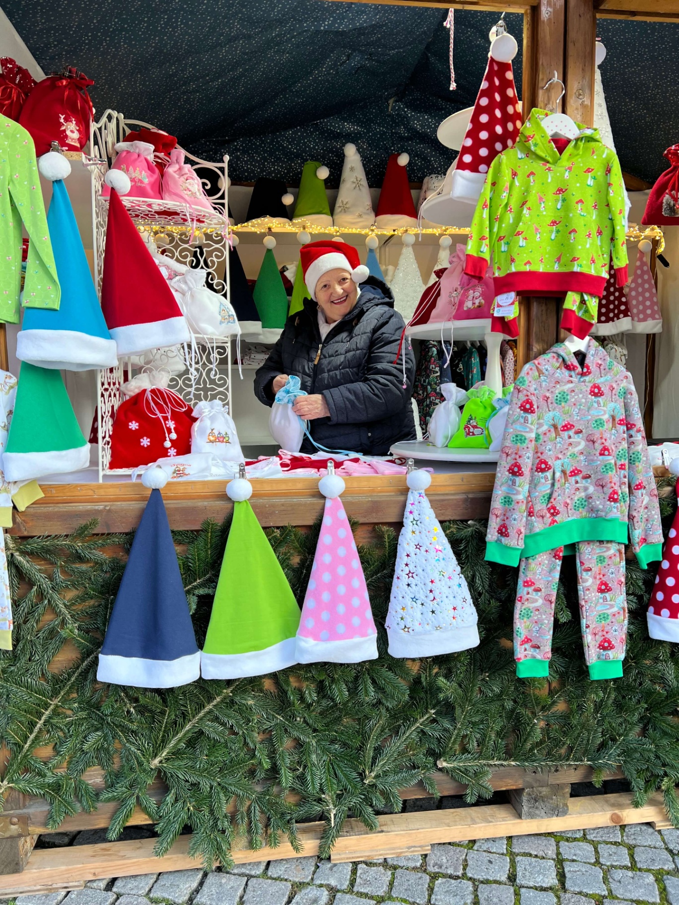 Emanuela am Stand mit bunten Weihnachtsmützen